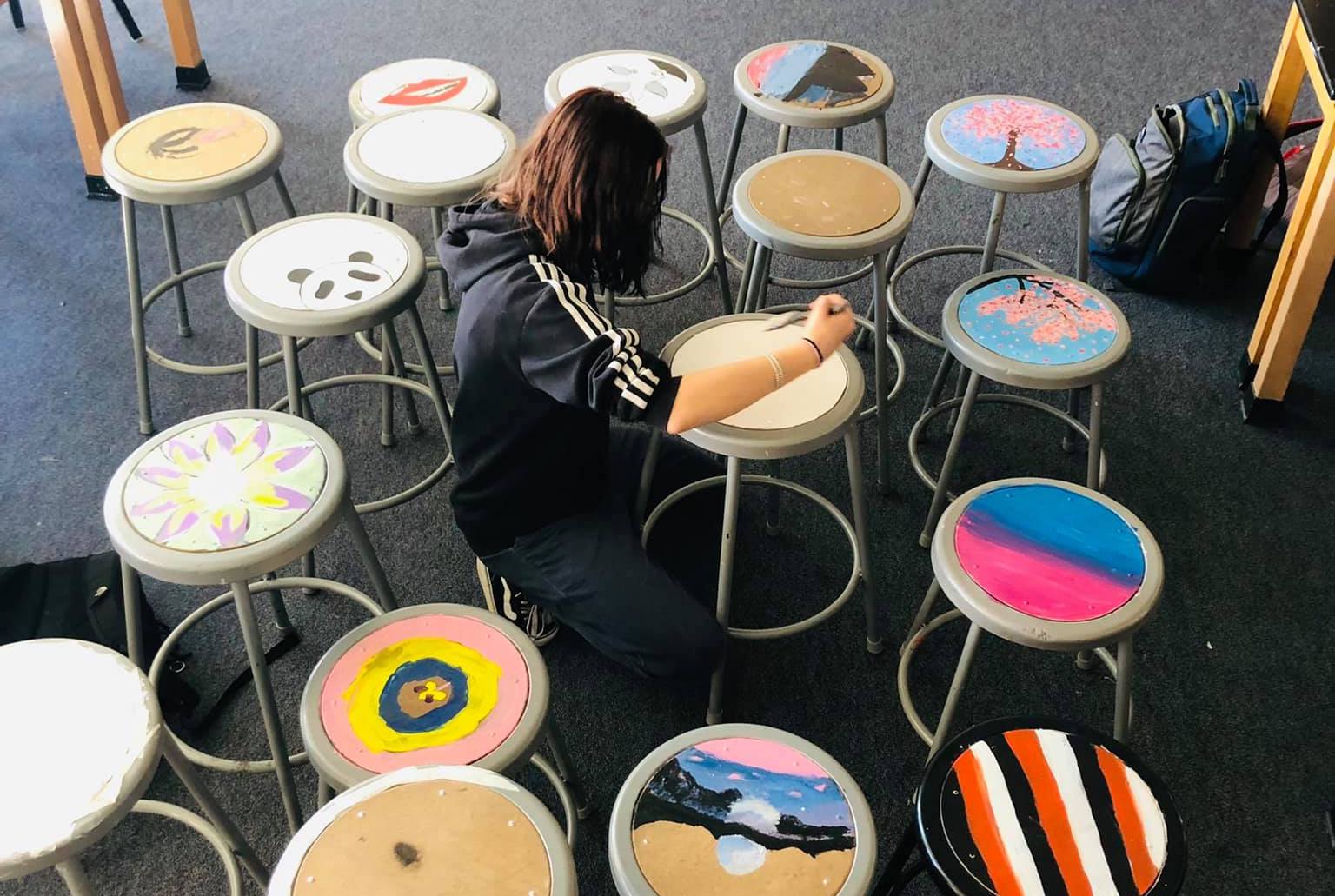 Student painting chairs